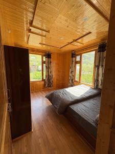a bedroom with a bed in a wooden house at Shubham homestay in Sissu