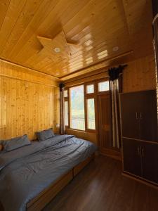a bedroom with a bed in a wooden cabin at Shubham homestay in Sissu