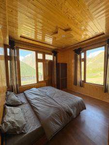 a bedroom with a bed in a room with windows at Shubham homestay in Sissu