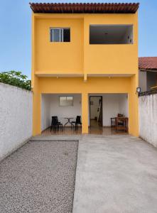 a yellow house with a patio in front of it at Casa Brisa do Mar in Tamandaré
