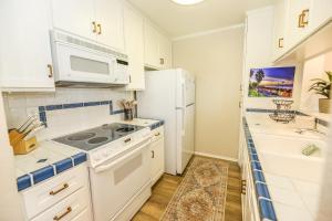 a kitchen with white appliances and a white refrigerator at C4 - Coastal Cottage in Oceanside +51 photos