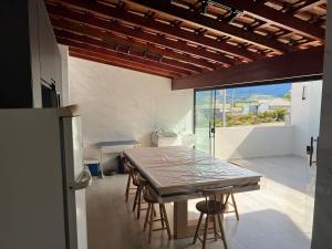 a kitchen with a table and chairs and a refrigerator at Casa Sonho Meu in Joanópolis