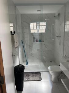 a white bathroom with a shower and a toilet at Casa Sonho Meu in Joanópolis +17 photos