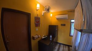 a room with a door and a yellow wall at Kiwi Backpackers Hostel Pokhara in Pokhara
