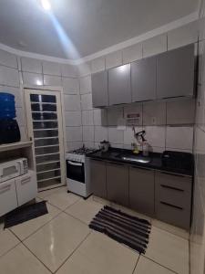 a kitchen with a sink and a stove top oven at Casa Prox Centro in Ribeirão Preto