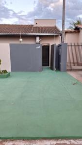 a house with a green floor and a garage at Suíte privativa com acesso à rua in Dourados +5 photos
