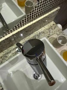 a faucet on a sink in a bathroom at Suite Boutique 101 Cheia de Graca in Divinópolis