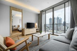 a living room with a couch and a large window at Oakwood Suites Bangkok in Bangkok