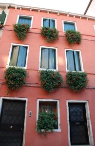 un edificio rosso con piante in vaso di Oceano Mare B&B a Venezia