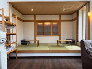 a room with two benches and a table in a room at Pension Lavender in Furano