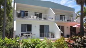 a white house with a balcony and trees at Arcadia Beach Unit 3 in Arcadia