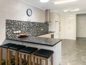 a kitchen with a counter with stools and a clock on the wall at Arcadia Beach Unit 3 in Arcadia