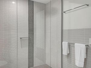 a bathroom with a glass shower with white towels at Blue on Blue Studio Room 1352 in Nelly Bay
