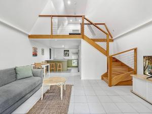 a living room with a couch and a staircase at Canopy Chalet 6 in Nelly Bay +11 photos