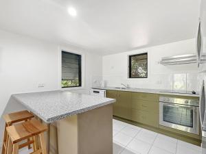 a kitchen with white walls and a counter top at Canopy Chalet 6 in Nelly Bay