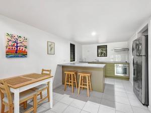 a kitchen with a table and chairs and a refrigerator at Canopy Chalet 6 in Nelly Bay