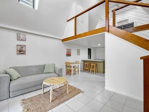 a living room with a couch and a table at Canopy Chalet 6 in Nelly Bay