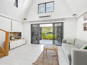 a living room with a couch and a table at Canopy Chalet 6 in Nelly Bay
