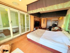 a bedroom with a large bed and a living room at avilla RESORT in Iwaki