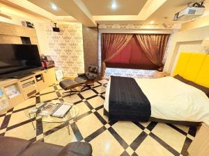 a bedroom with a bed and a tv and a couch at avilla RESORT in Iwaki