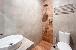 a bathroom with a white toilet and a shower at Urbanview Hotel Syariah Nawasena Guest House IKN by RedDoorz in Sepaku