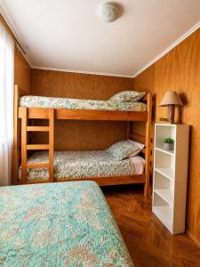 a bedroom with two bunk beds and a lamp at Viento Sur Astro Camping & Cabañas in Los Hornitos