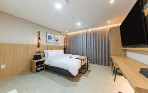 a hotel room with a bed and a flat screen tv at Daejeon Continew Hotel in Daejeon