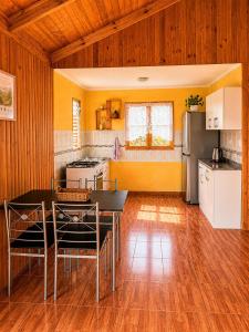 a kitchen with a table and chairs in a room at Viento Sur Astro Camping & Cabañas in Los Hornitos