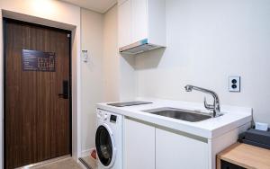 a kitchen with a sink and a washing machine at Daejeon Continew Hotel in Daejeon +44 photos