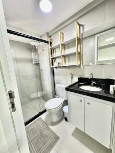 a bathroom with a toilet and a sink and a shower at Compacto Flat na Orla de Intermares in Cabedelo +19 photos