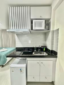 a kitchen with a sink and a microwave at Compacto Flat na Orla de Intermares in Cabedelo