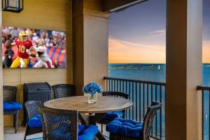 a table and chairs on a balcony with a tv at Lakefront Horseshoe Bay Resort Shared Pool Dock in Horseshoe Bay