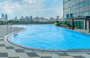 a large swimming pool with a city in the background at Hyatt Centric Zhongshan Park Shanghai in Shanghai