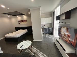 a room with a bed and a tv and a living room at Kent Suites Hotels Ataşehir in Istanbul