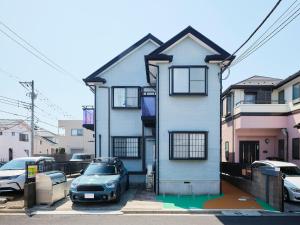 a white house with a car parked in a parking lot at DreamFriend新浦安 in Tokyo