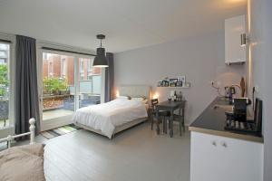 een slaapkamer met een bed en een keuken met een bureau bij Zandstudio in Alkmaar