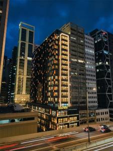a tall building in a city at night at The Bauhinia Hotel - Central in Hong Kong
