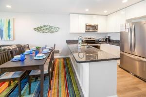 a kitchen and dining room with a table and a refrigerator at B306 - Endless Summer in Oceanside