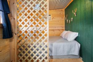 a small bedroom with a bed with a wooden wall at Nueces River Escape in Uvalde