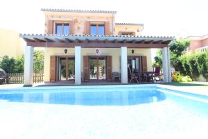 a villa with a swimming pool in front of a house at Villa Puerto Adriano in El Toro
