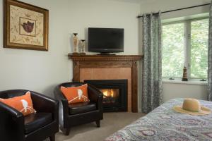 a living room with two chairs and a fireplace at Beech Tree Inn and Cottage in Newport