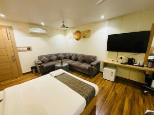 a living room with a couch and a flat screen tv at Hotel JK palace in Allahābād +53 photos