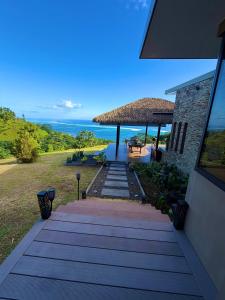 a pathway leading to a house with a straw umbrella at Villa Maeva Tahiti in Vaihi