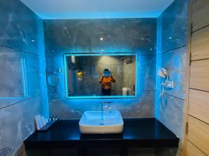 a bathroom with a mirror and a person wearing a mask at Hotel JK palace in Allahābād