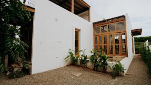 a white house with plants in front of it at Aguamiel Agua Blanca in Playa Agua Blanca