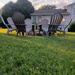 a group of three chairs and a table in the grass at Cliffside Cottage in Mansfield
