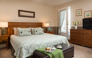 a bedroom with a bed with a green bedspread and a television at Beech Tree Inn and Cottage in Newport