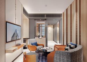 a living room with a couch and a tv at Mercure Bangkok Siam Ratchathewi in Bangkok