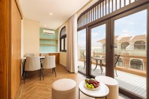 a room with a balcony with a table and chairs at Lumiere Boutique Vỹ Dạ in Thôn Lại Thê