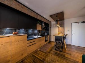 a kitchen with wooden cabinets and a black counter top at Deluxe Apartment Bono in Sinj